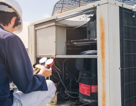 AC techncian repairing AC unit